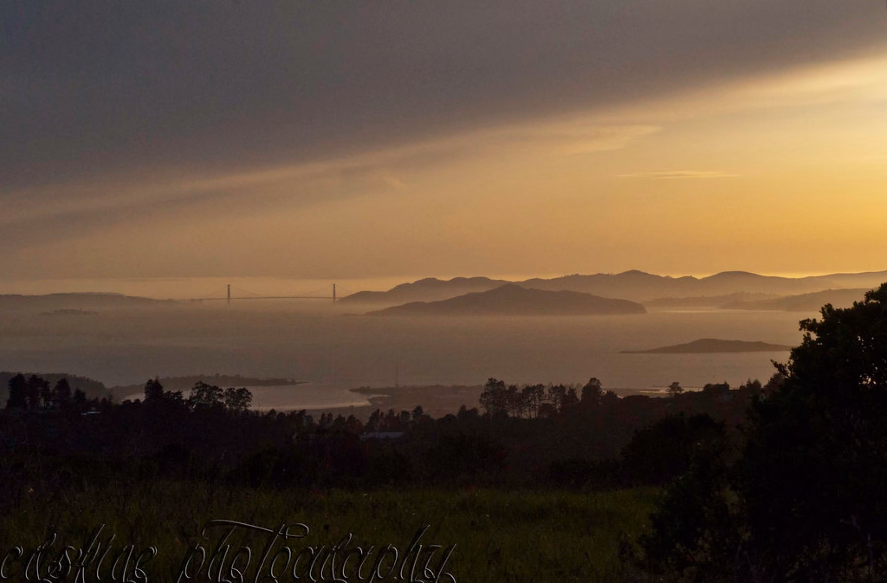 The bay at dusk from the hills, with the Golden Gate on the horizon.