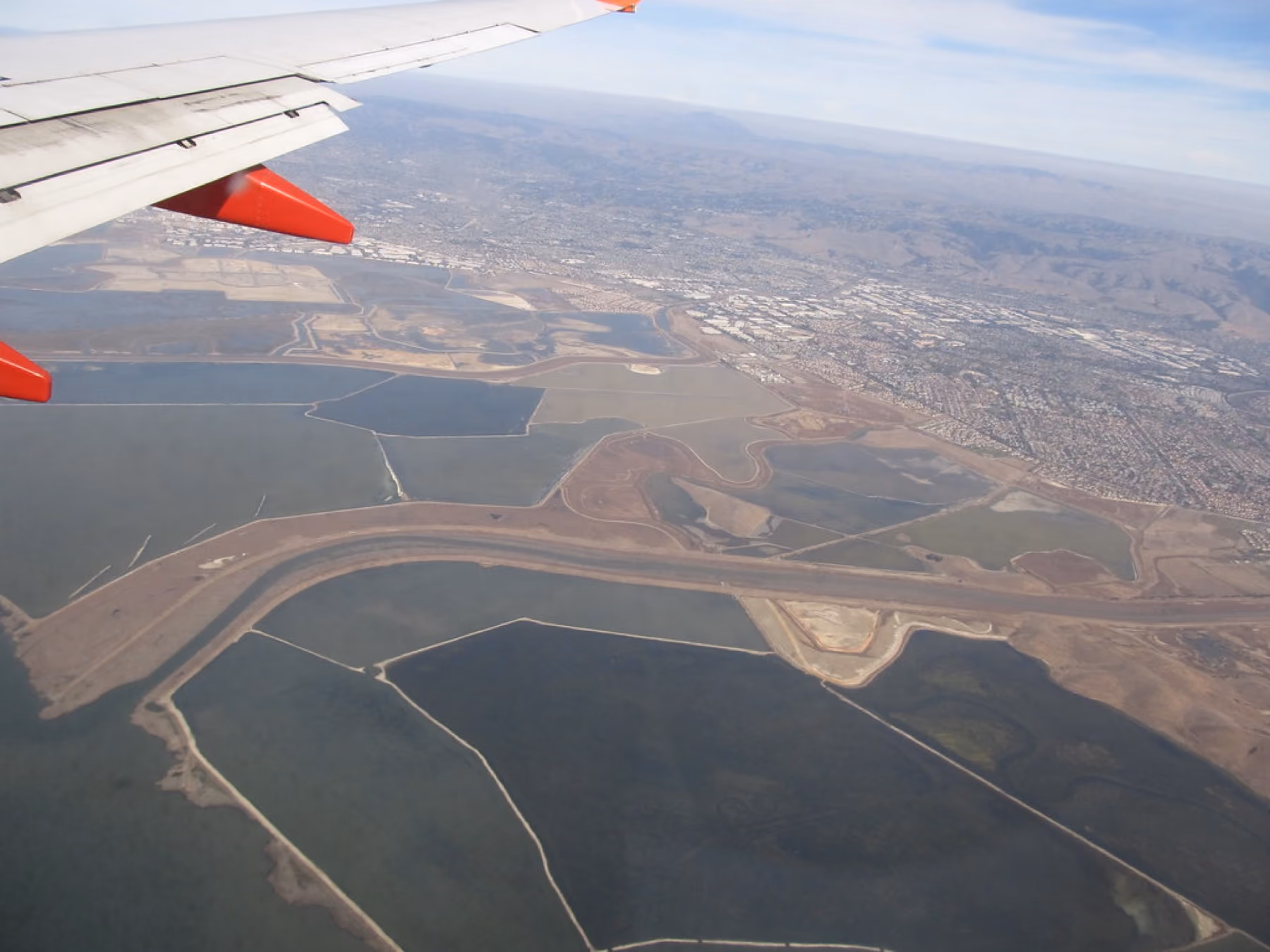 Salt ponds and levees on the bay shore seen from the air.