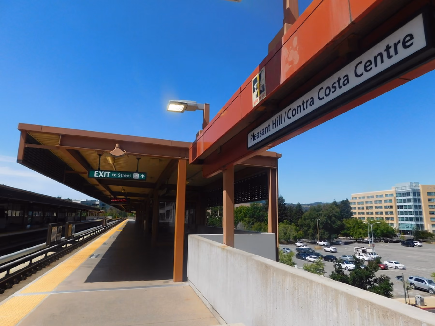 The platform canopy at the Pleasant Hill station with office buildings behind.